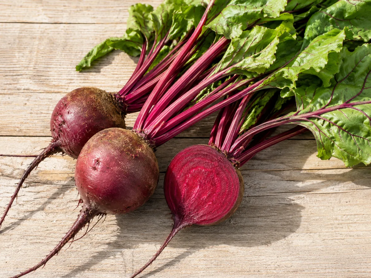 Fresh red beets with greens attached for a blood pressure-friendly food guide.